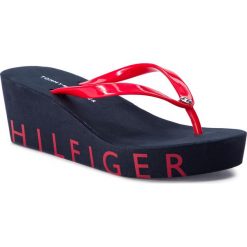Japonki TOMMY HILFIGER - Wedge Beach Sandal FW0FW04057 Tango Red 611. Czerwone klapki damskie TOMMY HILFIGER, bez wzorów, z tworzywa sztucznego, bez obcasa, na obcasie. W wyprzedaży za 139,00 zł.