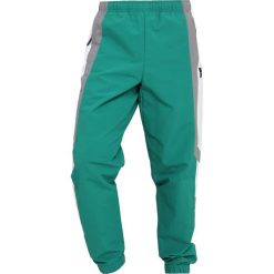 Adidas Originals WIND PANT Spodnie treningowe subgreen. Szare spodnie dresowe męskie marki adidas Originals, l, z nadrukiem, z bawełny, z kapturem. Za 379,00 zł.