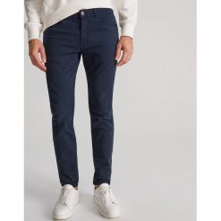Bawełniane spodnie slim fit - Granatowy. Niebieskie spodnie męskie Reserved, bez wzorów, z bawełny. W wyprzedaży za 59,99 zł.