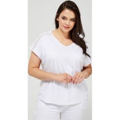 T-shirt z ażurowym zdobieniem. Białe bluzki damskie Moodo, w koronkowe wzory, z elastanu, klasyczne, z dekoltem w serek, z krótkim rękawem. Za 49,99 zł.
