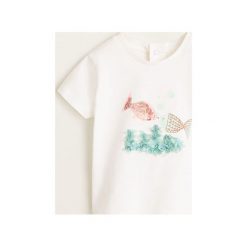 Mango Kids - Top dziecięcy Wanda 80-104 cm. Białe bluzki dziewczęce Mango Kids, z nadrukiem, z bawełny, z okrągłym kołnierzem, z krótkim rękawem, krótkie, bez kaptura. W wyprzedaży za 19,90 zł.