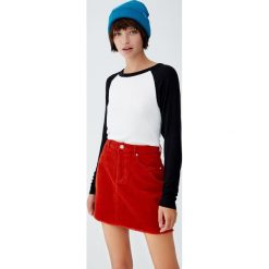 Koszulka z kontrastowym długim rękawem. Czarne bluzki damskie marki Pull&Bear, z kontrastowym kołnierzykiem, z długim rękawem. Za 49,90 zł.