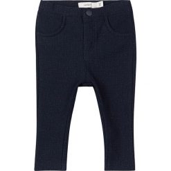 Spodnie "Redda" w kolorze granatowym. Niebieskie spodnie niemowlęce name it girls, bez wzorów, z bawełny. W wyprzedaży za 47,95 zł.