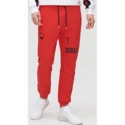 Joggery z nadrukami - Czerwony. Czerwone spodnie męskie Cropp, s, z nadrukiem. Za 119,99 zł.