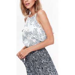 ZWIEWNA BLUZKA BEZ RĘKAWÓW W STYLU JESSICA MERCEDES. Białe bluzki damskie marki Top Secret, z nadrukiem, z tkaniny, eleganckie, z falbankami, bez rękawów. W wyprzedaży za 39,99 zł.