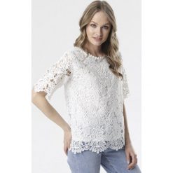Biała Bluzka Raisea. Białe bluzki damskie Born2be, xl, w koronkowe wzory, z koronki, eleganckie, z okrągłym kołnierzem, z krótkim rękawem. Za 69,99 zł.