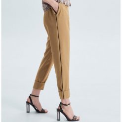 Materiałowe spodnie tailoring - Beżowy. Brązowe spodnie damskie Cropp, bez wzorów, z tkaniny. W wyprzedaży za 29,99 zł.
