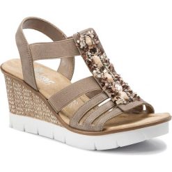 Sandały RIEKER - 65596-64 Beige 1. Brązowe klapki damskie Rieker, bez wzorów, ze skóry ekologicznej, bez obcasa, na obcasie. W wyprzedaży za 179,00 zł.
