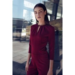Elegancki kombinezon z rozcięciem na dekolcie - bordo. Kombinezony damskie NIFE, xl, bez wzorów, z elastanu, eleganckie, bez kołnierzyka, bez rękawów. Za 199,00 zł.