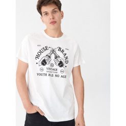 T-shirt z nadrukiem Kremowy. Białe t-shirty męskie House, s, z nadrukiem, bez kołnierzyka. W wyprzedaży za 19,99 zł.