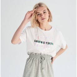 T-shirt z holograficzną aplikacją - Biały. Białe t-shirty damskie marki Sinsay, s, z aplikacjami, bez kołnierzyka. Za 19,99 zł.