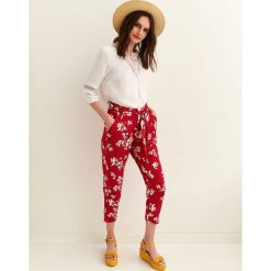 Spodnie 7/8 damskie z podwyższonym stanem. Czerwone spodnie damskie Top Secret, na lato, w kwiaty, z tkaniny, eleganckie, z podwyższonym stanem. W wyprzedaży za 39,99 zł.