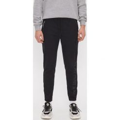 Joggery z nadrukiem - Czarny. Czarne spodnie męskie House, s, z nadrukiem. W wyprzedaży za 67,99 zł.