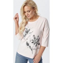 Jasnoróżowa Bluzka Aurathia. Różowe bluzki damskie Born2be, xl, z nadrukiem, z dzianiny, z okrągłym kołnierzem, z długim rękawem. Za 59,99 zł.