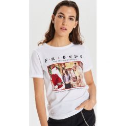 Koszulka świąteczne Friends - Biały. Białe koszulki damskie Cropp, s, bez wzorów, wizytowe, bez kołnierzyka, bez rękawów. Za 59,99 zł.