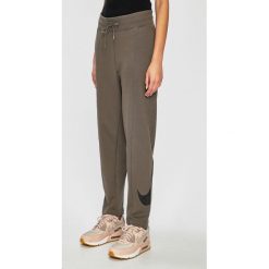 Nike Sportswear - Spodnie. Pomarańczowe spodnie damskie marki Nike Sportswear, s, z bawełny. Za 229,90 zł.