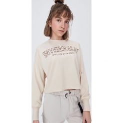 Krótka bluza z napisem - Kremowy. Białe bluzy damskie Sinsay, s, z napisami, z krótkim rękawem, krótkie, bez kaptura. W wyprzedaży za 15,99 zł.