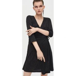 Kopertowa sukienka mini z wiązaniem - Czarny. Czarne sukienki damskie Cropp, s, bez wzorów, bez kołnierzyka, bez rękawów, mini, kopertowe. Za 89,99 zł.