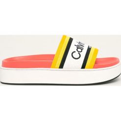 Calvin Klein - Klapki. Żółte klapki damskie Calvin Klein, bez wzorów, z materiału, bez obcasa, na obcasie. W wyprzedaży za 299,90 zł.