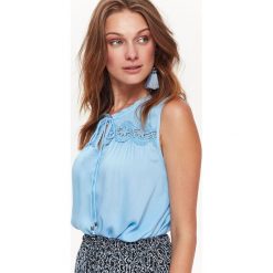 Bluzka bez rękawów damska z koronkową aplikacją. Niebieskie bluzki damskie Top Secret, z aplikacjami, z tkaniny, eleganckie, bez kołnierzyka, bez rękawów. W wyprzedaży za 39,99 zł.