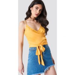 Linn Ahlborg x NA-KD Kopertowy top z wiązaniem - Yellow. Żółte topy damskie marki Linn Ahlborg x NA-KD, bez wzorów, bez kołnierzyka. W wyprzedaży za 56,78 zł.