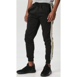 Czarno-Żółte Spodnie Saloria. Czarne spodnie męskie Born2be, xl, bez wzorów, z dresówki. W wyprzedaży za 54,99 zł.