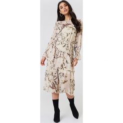 Trendyol Sukienka midi z falbaną - Nude. Szare sukienki damskie Trendyol, bez wzorów, bez kołnierzyka, z długim rękawem, długie, midi. Za 202,95 zł.