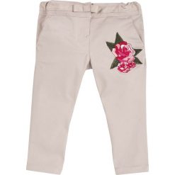 Spodnie w kolorze beżowym. Brązowe spodnie niemowlęce marki Chicco, z aplikacjami. W wyprzedaży za 67,95 zł.