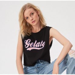 Krótki tank top z napisem retro - Czarny. Czarne topy damskie Sinsay, s, z napisami, bez kołnierzyka. W wyprzedaży za 9,99 zł.
