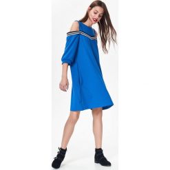 DZIANINOWA SUKIENKA DAMSKA Z MODNĄ TAŚMĄ, COLD SHOULDER. Niebieskie sukienki damskie Top Secret, na co dzień, na zimę, m, bez wzorów, z dzianiny, eleganckie, bez kołnierzyka, bez rękawów, z odkrytymi ramionami. W wyprzedaży za 39,99 zł.
