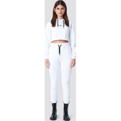 Sahara Ray x NA-KD Spodnie dresowe z kontrastowym troczkiem - White. Białe spodnie damskie Sahara Ray x NA-KD, z dzianiny. W wyprzedaży za 80,97 zł.