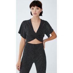 Metaliczna bluzka z węzłem. Czarne bluzki damskie Pull&Bear, bez wzorów, bez kołnierzyka, bez rękawów. Za 79,90 zł.