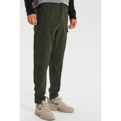 Spodnie z kieszeniami cargo - Khaki. Brązowe spodnie męskie Cropp, m, bez wzorów. Za 149,99 zł.