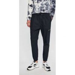 Armani Exchange - Spodnie. Niebieskie spodnie męskie Armani Exchange, na co dzień, bez wzorów, z bawełny, casualowe. W wyprzedaży za 329,90 zł.