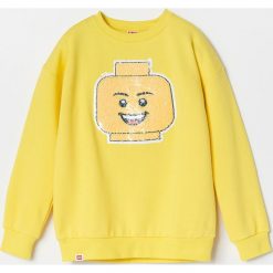 Bluza dresowa z aplikacją Lego - Żółty. Żółte bluzy męskie Reserved, m, z aplikacjami, z dresówki, bez kołnierzyka, bez rękawów, bez kaptura. Za 79,99 zł.