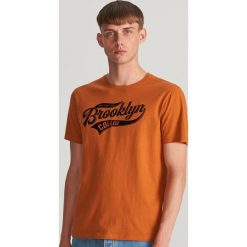 T-shirt z błyszczącym nadrukiem - Brązowy. Pomarańczowe t-shirty damskie Reserved, s, z nadrukiem, bez kołnierzyka. Za 39,99 zł.