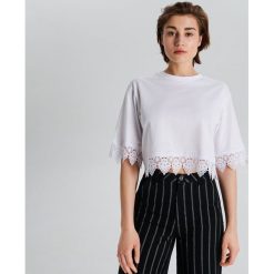Krótka bluzka oversize z koronką - Biały. Białe bluzki damskie Cropp, s, w koronkowe wzory, z koronki, bez kołnierzyka, z krótkim rękawem. Za 39,99 zł.