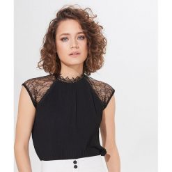 Elegancka bluzka ze stójką - Czarny. Czarne bluzki damskie Mohito, s, bez wzorów, eleganckie, ze stójką, bez rękawów. W wyprzedaży za 49,99 zł.