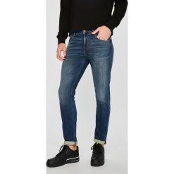 Guess Jeans - Jeansy Chris. Niebieskie jeansy męskie skinny marki Guess Jeans, z aplikacjami, z bawełny. W wyprzedaży za 349,90 zł.
