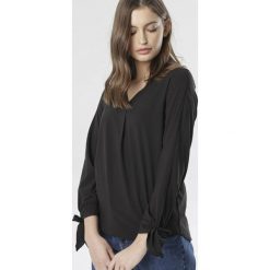 Czarna Bluzka Ocerah. Czarne bluzki damskie Born2be, do pracy, bez wzorów, eleganckie, bez kołnierzyka, z długim rękawem. Za 59,99 zł.
