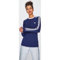 Adidas Originals - Bluzka. Niebieskie topy damskie adidas Originals, z aplikacjami, z elastanu, z okrągłym kołnierzem. W wyprzedaży za 149,90 zł.