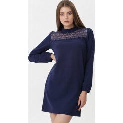 Ciemnoniebieska Sukienka Juliettice. Niebieskie sukienki damskie Born2be, s, bez wzorów, z koronki, eleganckie, ze stójką, bez rękawów, długie, mini, trapezowe. Za 99,99 zł.