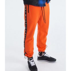 Spodnie joggery kolekcja Night Animals - Pomarańczowy. Pomarańczowe spodnie męskie marki Cropp, s, bez wzorów. Za 119,99 zł.