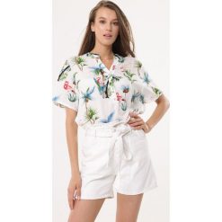 Biała Koszula Stellar Eagle. Białe bluzki damskie Born2be, xl, z nadrukiem, wakacyjne, z dekoltem w serek, z krótkim rękawem. Za 49,99 zł.