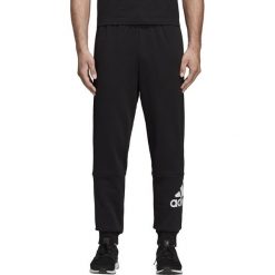 MĘSKIE SPODNIE MUST HAVES FRENCH TERRY (M). Czarne spodnie męskie Adidas, m, bez wzorów, z bawełny, klasyczne. W wyprzedaży za 139,99 zł.