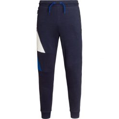 Spodnie dresowe EA7 EMPORIO ARMANI. Niebieskie spodnie męskie EA7 Emporio Armani, z nadrukiem, z bawełny. Za 440,00 zł.