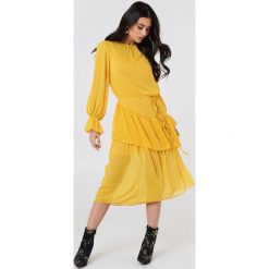 Trendyol Sukienka midi z falbaną - Yellow. Żółte sukienki damskie Trendyol, bez wzorów, z poliesteru, bez kołnierzyka, z długim rękawem, długie, midi. W wyprzedaży za 101,47 zł.