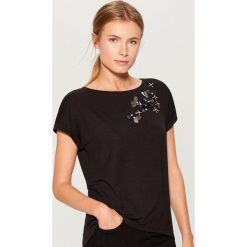 Koszulka z aplikacją - Czarny. Czarne t-shirty damskie Mohito, l, z aplikacjami. W wyprzedaży za 39,99 zł.
