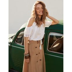 Luźna bluzka z aplikacją. Białe bluzki damskie Top Secret, z aplikacjami, z tkaniny, eleganckie, bez kołnierzyka, bez rękawów. W wyprzedaży za 49,99 zł.