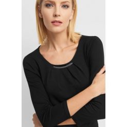Koszulka z metalową wstawką. Czarne bluzki damskie Orsay, na imprezę, s, z aplikacjami, z elastanu, eleganckie, z okrągłym kołnierzem. W wyprzedaży za 55,00 zł.